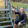 Christopher is posing in a playground next to steps that need to be repainted.